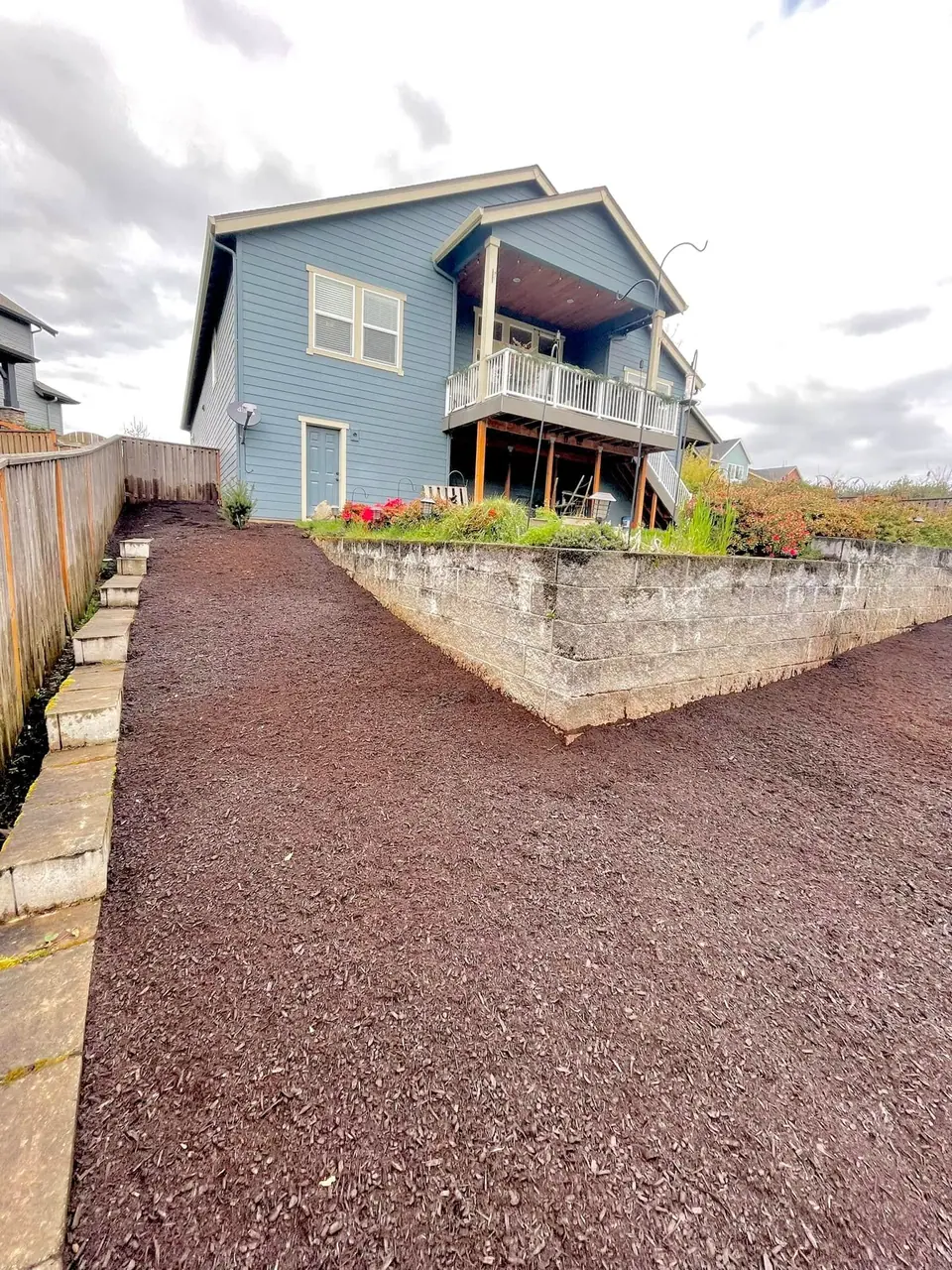 Block retaining wall with gravel backfill and a raised planting bed