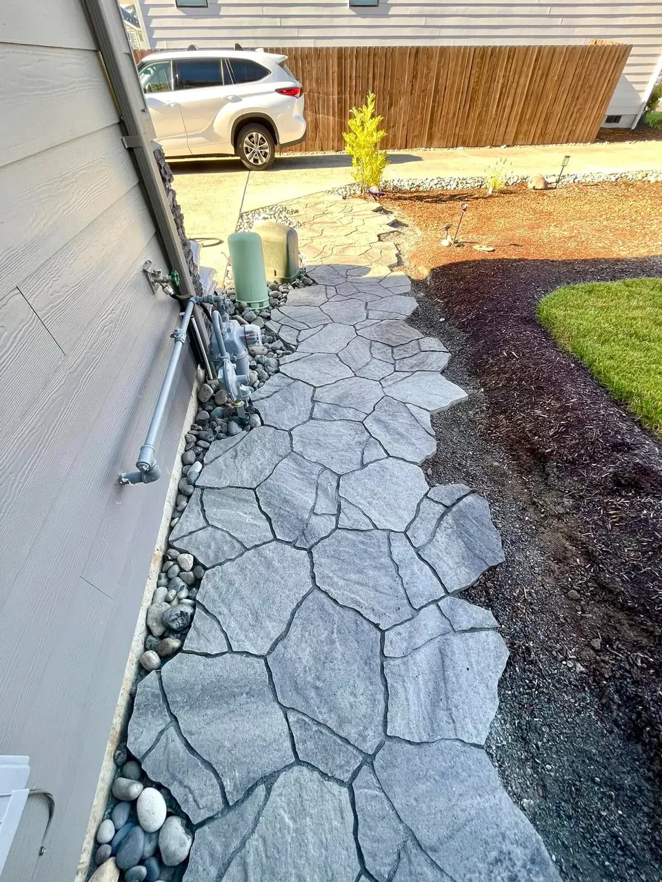 Flagstone patio being set with fresh mulch beds alongside