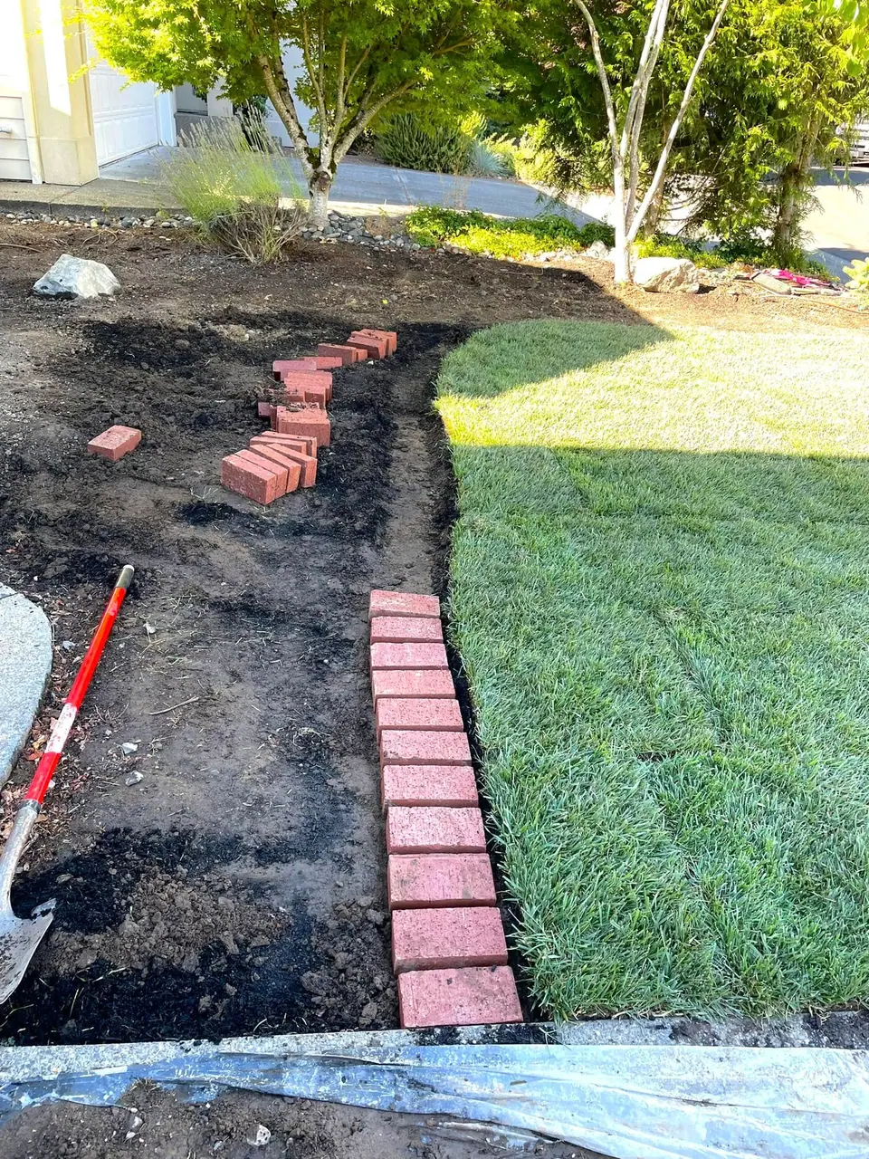 Paver edging set before fresh sod is rolled into place