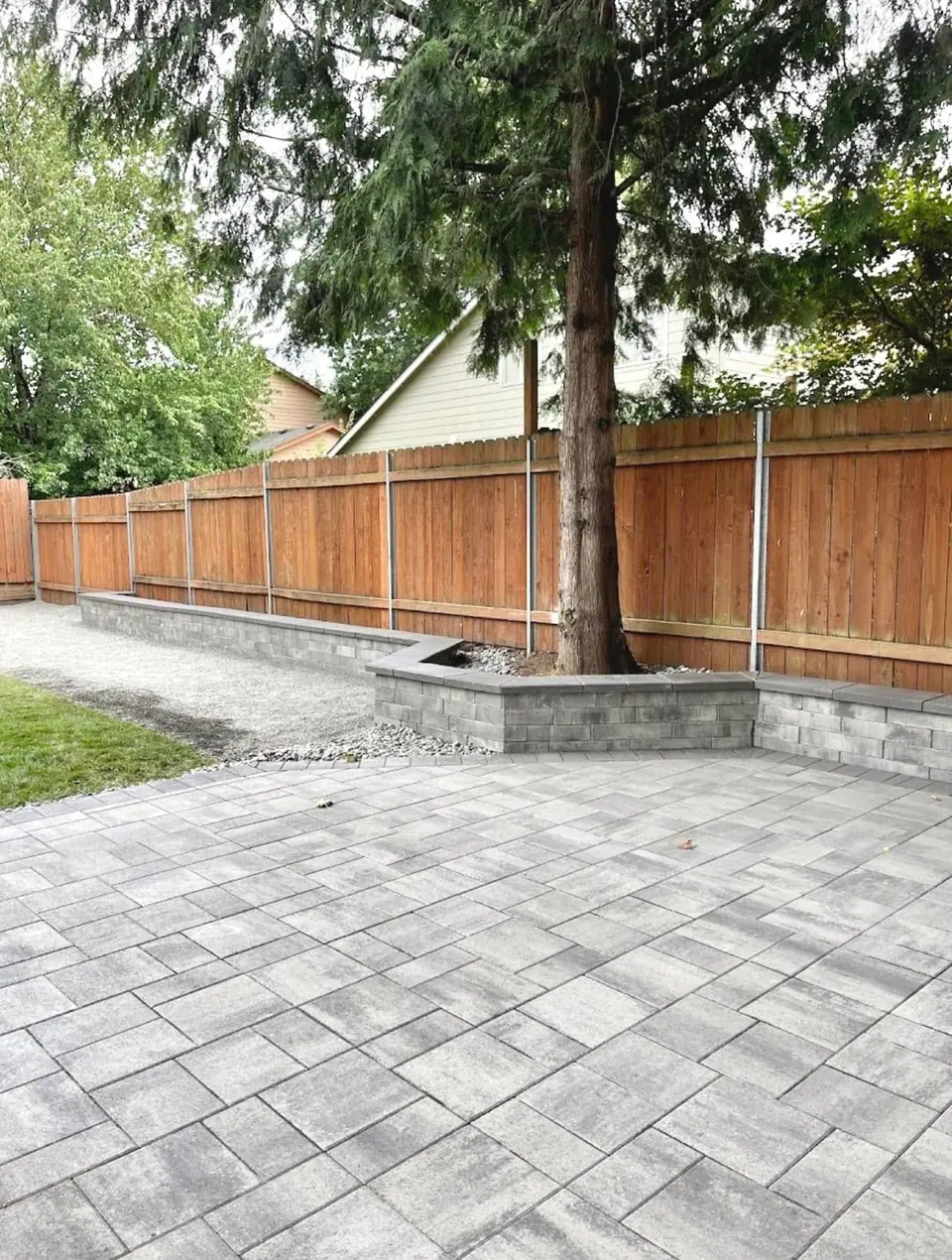 Paver tree ring and patio finished inside a new cedar fence