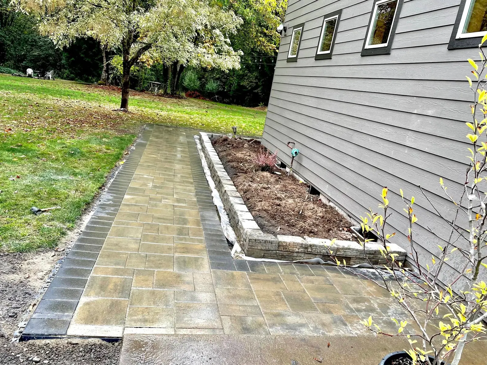 Paver walkway with a block retaining edge leading to a driveway